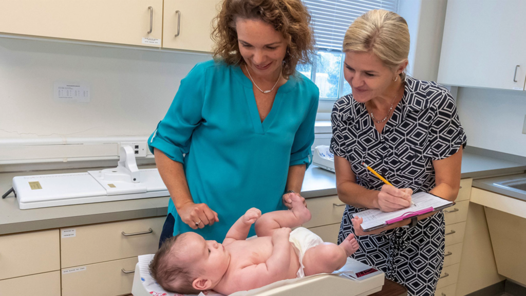 UNCG professors Esther Leerkes and Cheryl Buehler weigh an infant